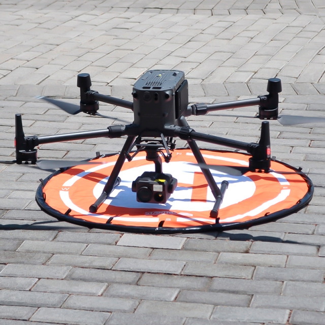 Drohnenlandepad, Ø 950 mm, aus 900D-Polyester-PU-Gewebe, weiß, Aufdruck orange mit Symbol Hubschrauberlandeplatz